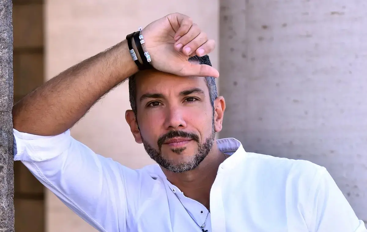 Antonio Mezzancella sorridente durante un'esibizione dal vivo di cabaret e comicità
